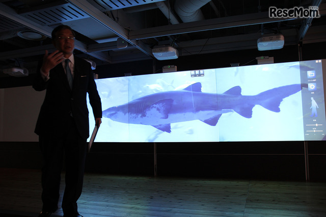 「ちょっと魚の写真を出してください」　大久保氏の呼びかけに応じ、スクリーンに実物大のサメの遊泳する姿が表示された（ICT・IoTを活用した教育環境例のデモンストレーション）