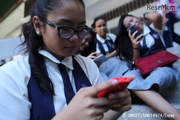 授業後に携帯電話を使う16歳の少女（フィリピン）　(c) UNICEF_UN014974_Estey