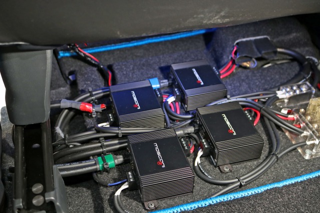 助手席下を見ると4台のパワーアンプ（モスコニPICO2）がコンパクトに取り付けられる。パネル底面にはDSPウルトラも設置する。