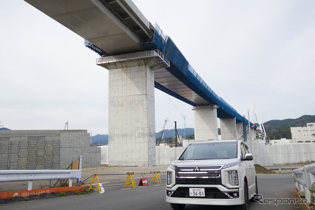 三菱 デリカD：5 アーバンギア。宮城・気仙沼にて。背景は竣工し、道路艤装中の三陸道気仙沼湾横断橋。