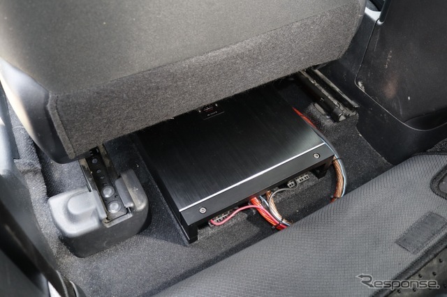 運転席／助手席ともにパワーアンプのサイズは完全には収めきれず、後部座席の足もとスペースにせり出しているのがわかる。